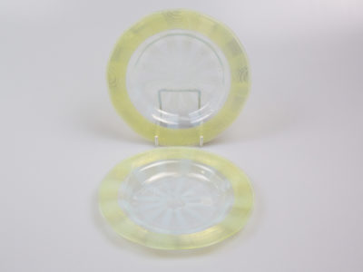 Pair of Art Deco glass side dishes. Handmade small shallow dishes with an unusual colour pattern of pale blue star burst to the centre and yellow green rim. Some minor signs of wear. Each dish measures approximately 100mm in diameter at base, 165mm across the top and 15mm in depth. Main photo showing one dish upright on a stand and other laid flat in front