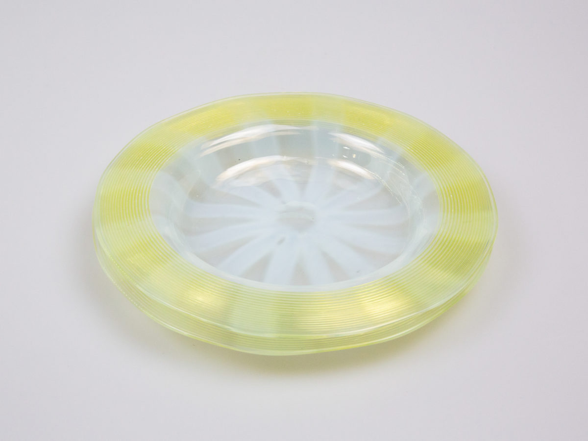 Pair of Art Deco glass side dishes. Handmade small shallow dishes with an unusual colour pattern of pale blue star burst to the centre and yellow green rim. Some minor signs of wear. Each dish measures approximately 100mm in diameter at base, 165mm across the top and 15mm in depth. Photo of both dishes on top of each other showing the starburst pattern clearly in the centre
