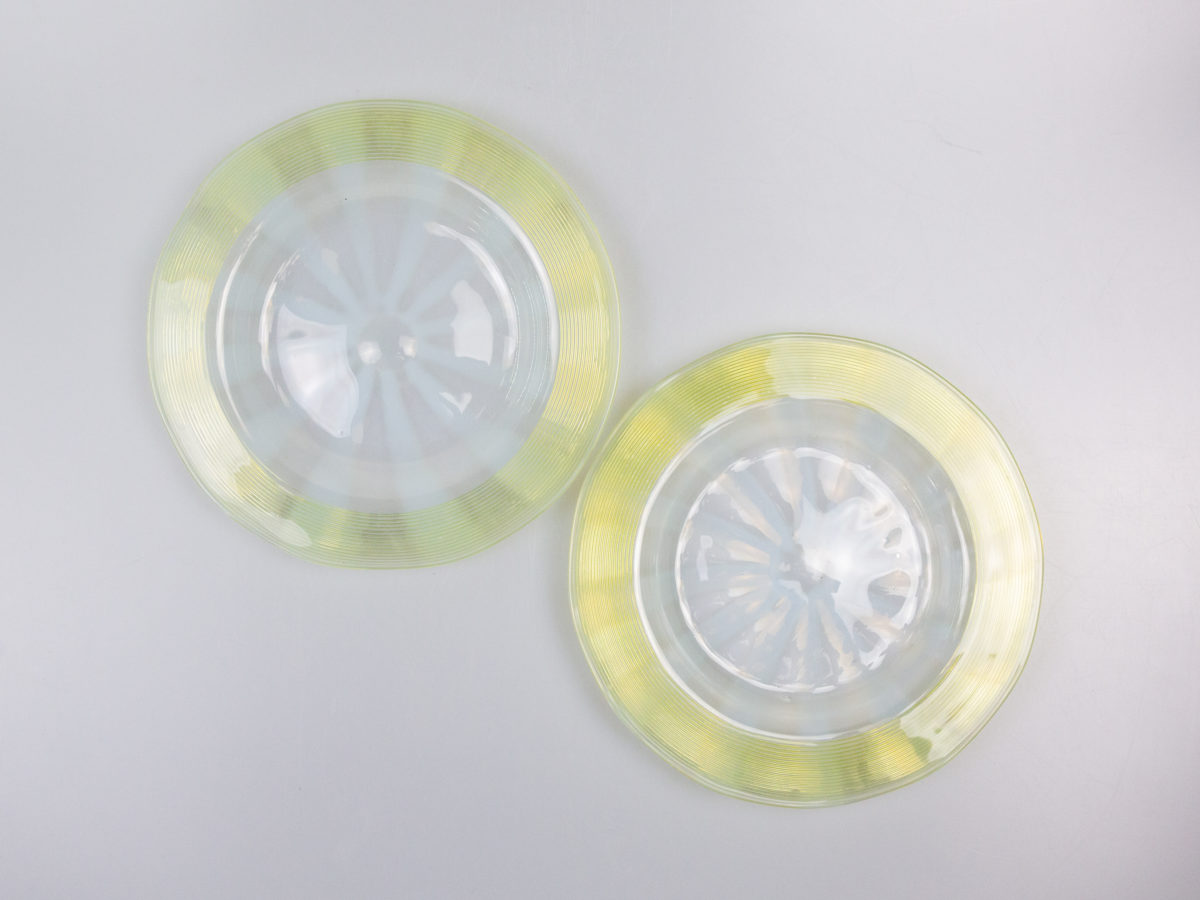 Pair of Art Deco glass side dishes. Handmade small shallow dishes with an unusual colour pattern of pale blue star burst to the centre and yellow green rim. Some minor signs of wear. Each dish measures approximately 100mm in diameter at base, 165mm across the top and 15mm in depth. Photo of both dishes laid diagonally side by side