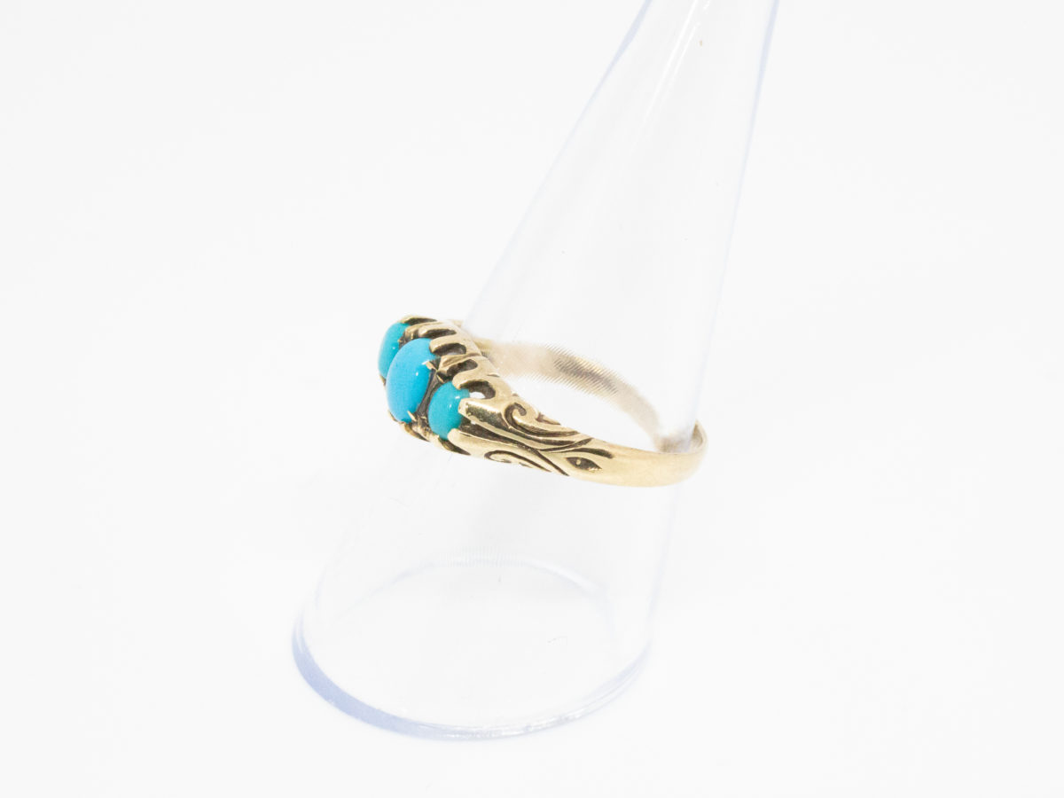 Vintage 9 karat gold and turquoise ring. Fully hallmarked 9 karat gold ring set with 3 sleeping beauty turquoise stones. Birmingham assay c1990. Ring size Q / 8.  Ring weight 2.4grams Photo of ring on a clear cone display stand and seen from a side angle