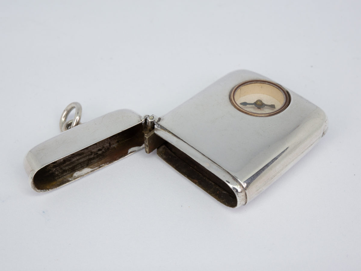 Sterling silver vesta with compass. Small silver vesta set with a small compass to one side. Fully hallmarked to the inside rim for Birmingham assay c1900 Photo of vesta laid on a flat surface with top open and seen just looking into the case and inside lid