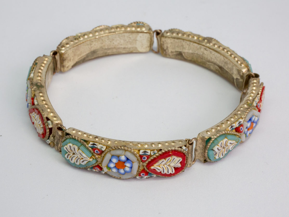 Vintage Italian micro mosaic bracelet. 5 panel white metal bracelet inlaid with micro mosaic beads in a pretty floral design. In very good order throughout with only 1 small bead missing. Photo of closed bracelet