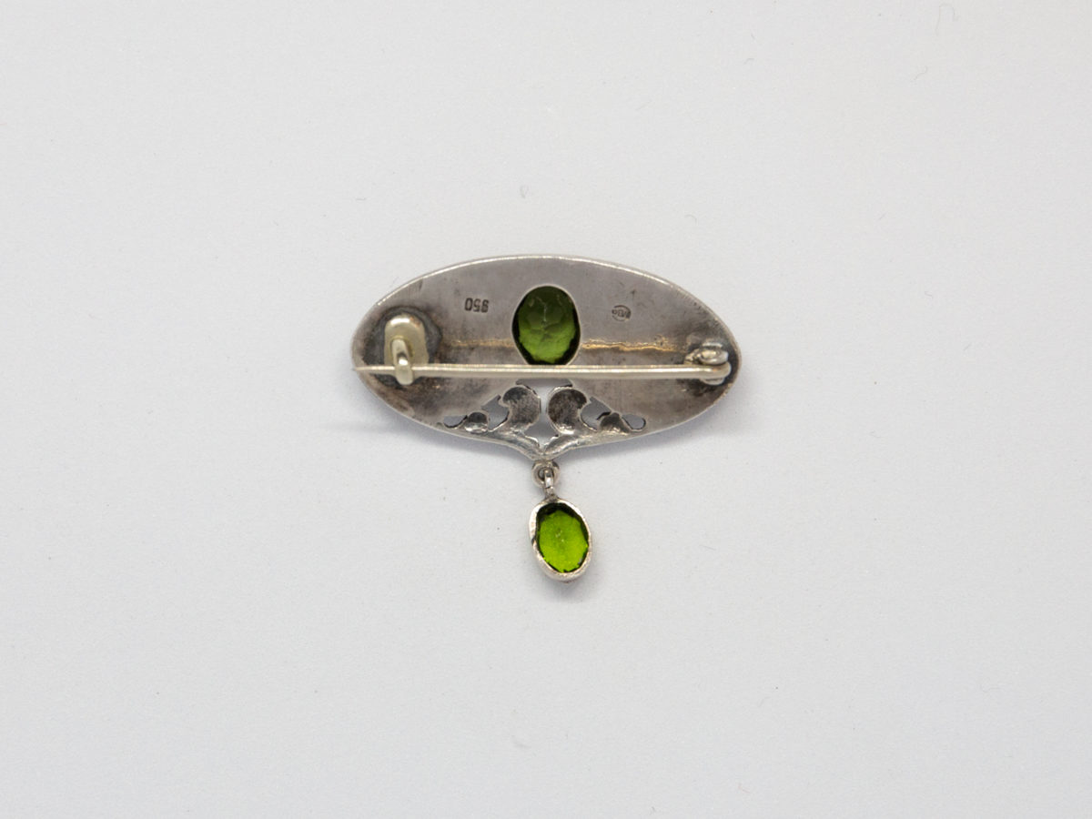Art Nouveau brooch in 950 grade silver and peridot. Fine Art Nouveau brooch by Murrle Bennett & Co in a classic Art Nouveau design with 2 oval cut peridot stones. Hallmarked to the back. Photo of back of brooch.