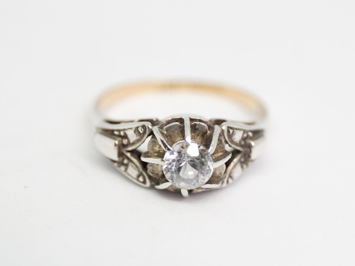 Art Deco 9 karat gold and silver ring. Round cut paste stone set high and held in place with 8 prongs all on silver mount with a 9 karat gold band. Hallmarked 9ct Silver to the inside band. Ring size L.5 / 6 Photo of ring on a flat surface and seen from the front