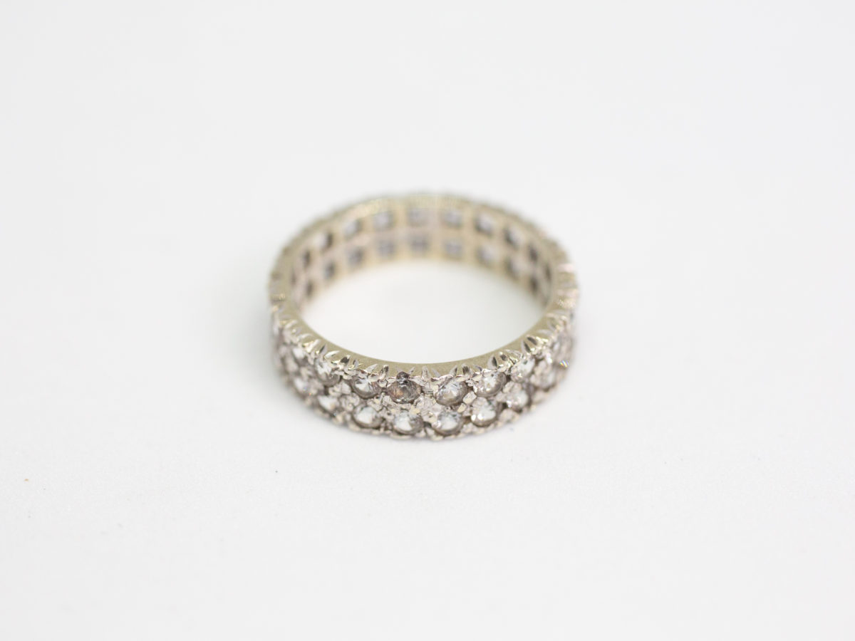 9 karat white gold & spinel ring. White gold ring with 2 rows of spinel stones that go all around. Beautifully sparkly ring for any occasion. Ring size K / 5.25. Photo of ring laid on a flat surface
