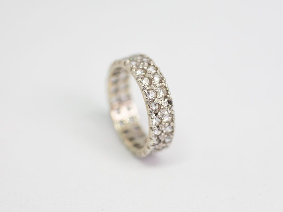 9 karat white gold & spinel ring. White gold ring with 2 rows of spinel stones that go all around. Beautifully sparkly ring for any occasion. Ring size K / 5.25. Photo of ring freestanding on its side with spinel stones facing bottom right