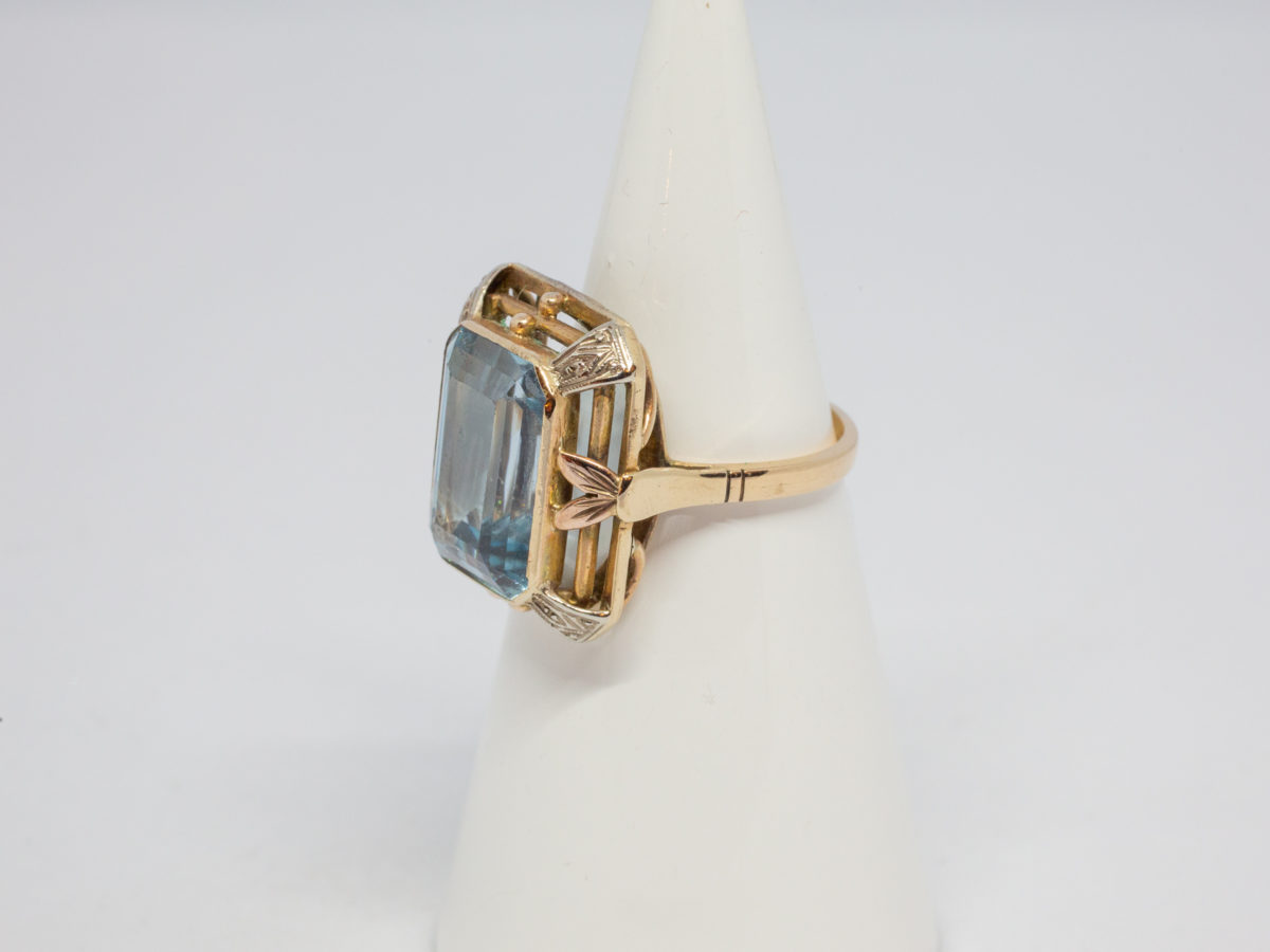 Antique 18 karat gold ring with blue topaz. c1920s large statement ring set with a large emerald cut pale blue topaz. Ring size R.5 / 8.75 Ring weight 8.6gms Photo of ring on a cone display stand with ring front facing left of photo.