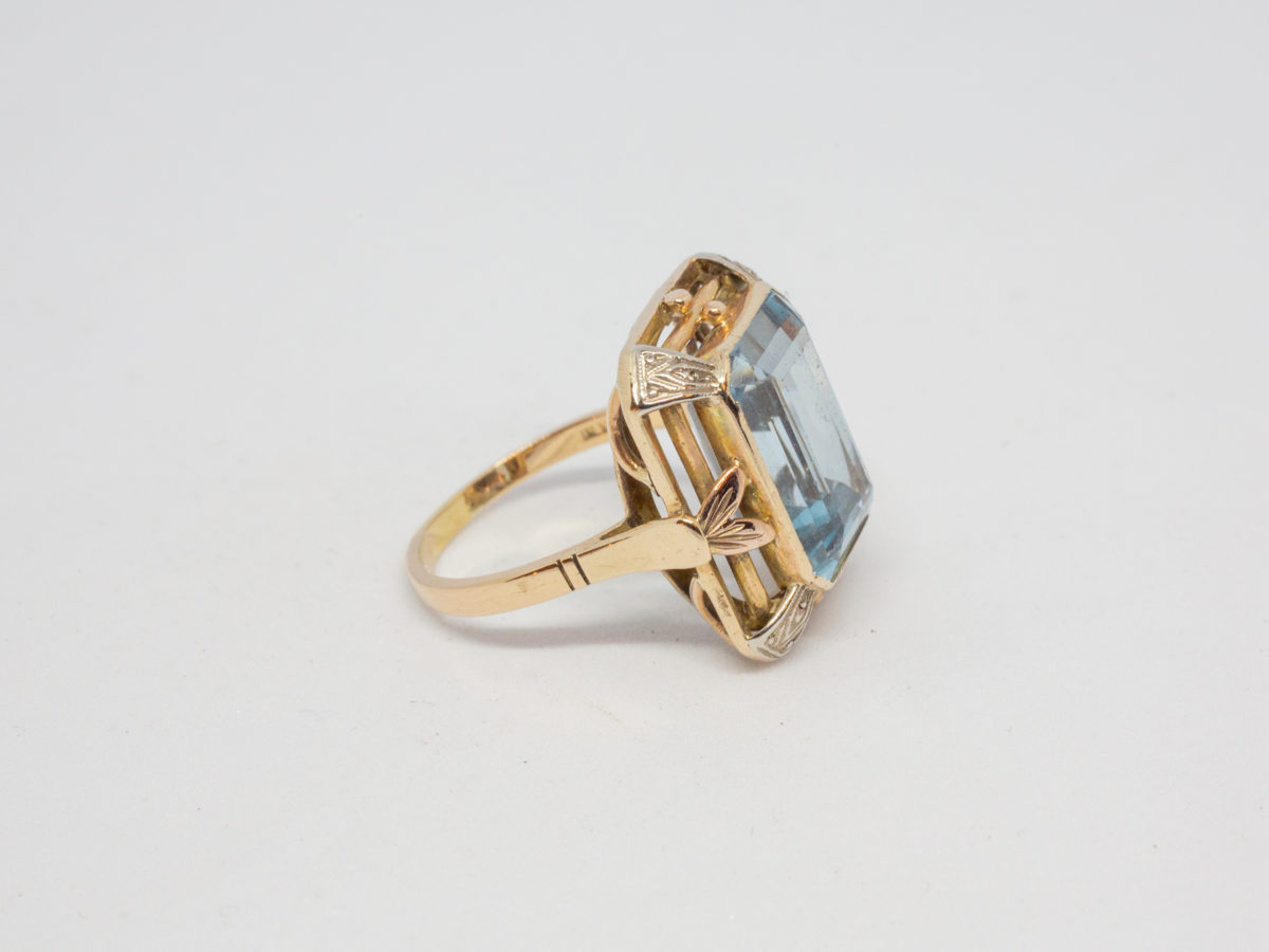 Antique 18 karat gold ring with blue topaz. c1920s large statement ring set with a large emerald cut pale blue topaz. Ring size R.5 / 8.75 Ring weight 8.6gms Photo of ring on a flat surface with ring front facing right