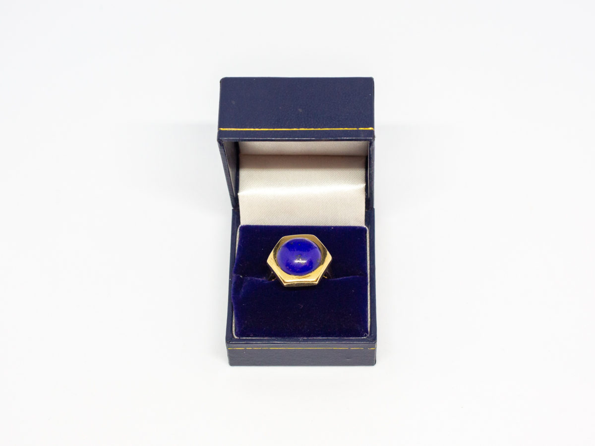 18 karat gold and lapis lazuli ring. Beautiful round lapis stone set on an unusual high hexagonal 18 karat gold mount. Size M.5 / 6.5. Weight 8.1gms. Box included. Photo of ring displayed in a box (included)