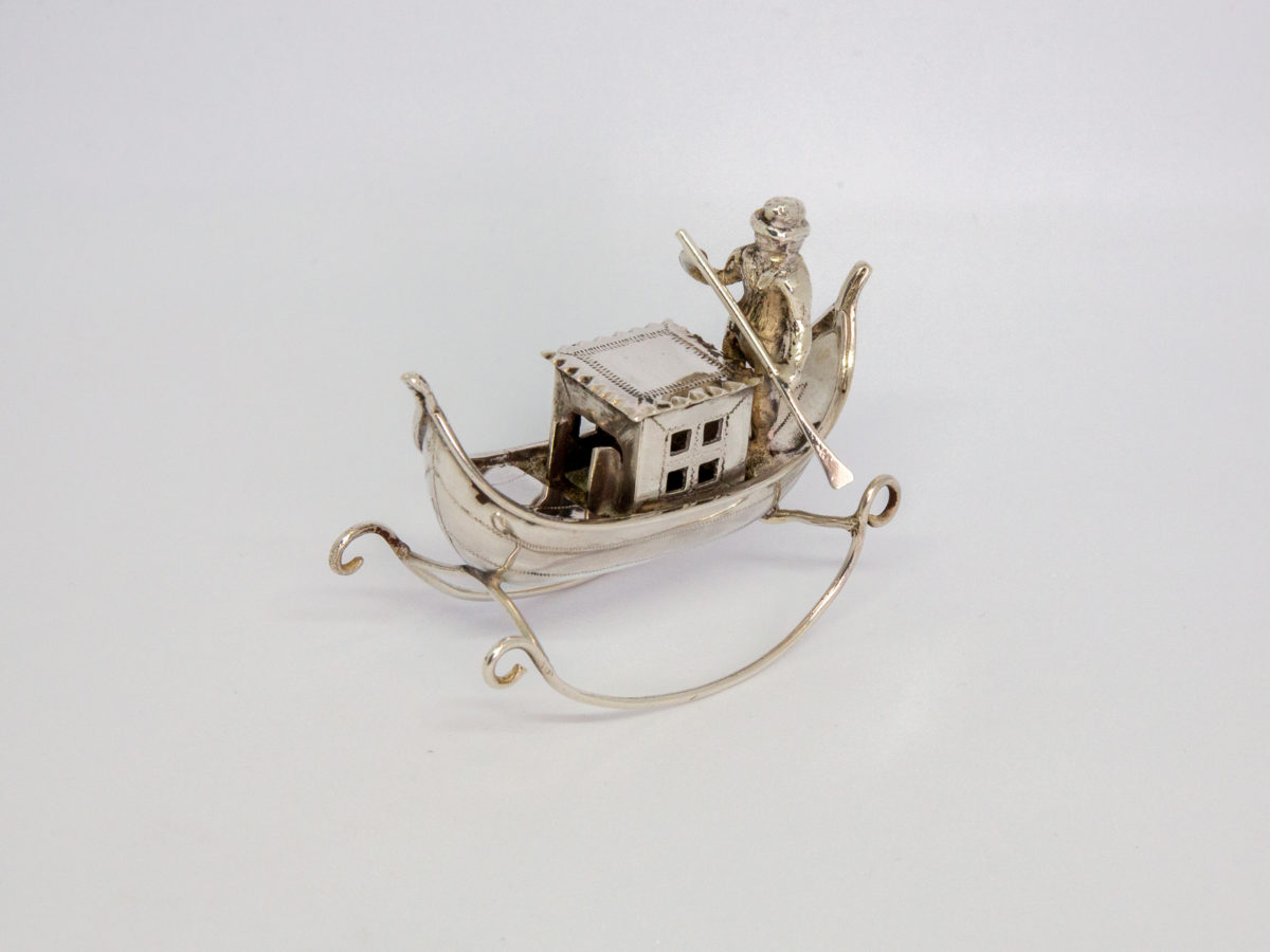 Vintage Dutch silver novelty gondolier. Solid silver decorative piece with full Dutch hallmark to the base. Photo of gondolier from an off side angle with front end of gondola facing bottom left of picture
