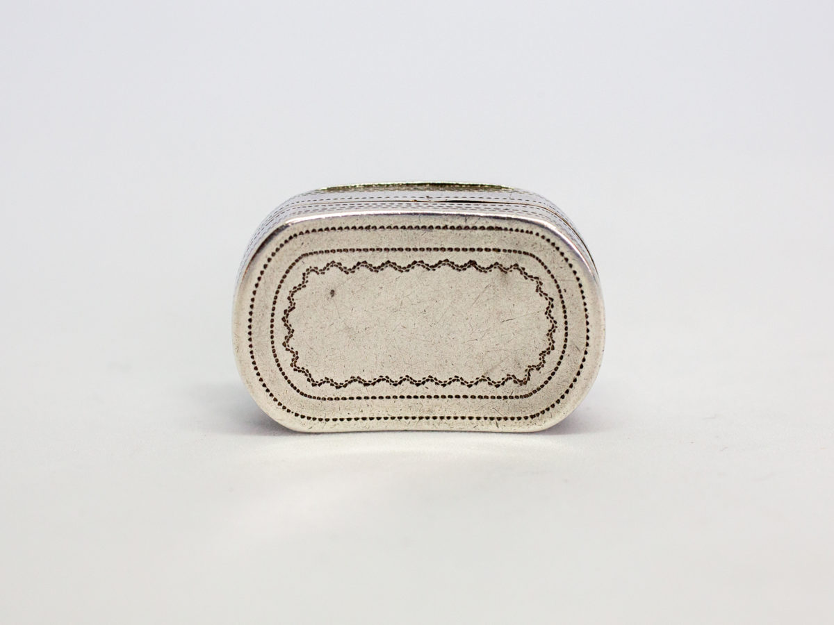 c1807 George III silver vinaigrette. An oblong sterling silver vinaigrette with a curved bottom and a gilt silver interior and grille. Fully hallmarked to the inside of lid for Birmingham assay by silversmith Cocks & Bettridge. A couple of minor dings but closes tight. Photo of the curved base end