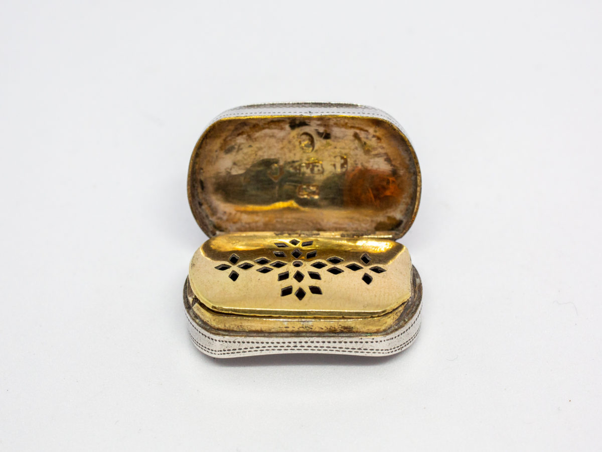 c1807 George III silver vinaigrette. An oblong sterling silver vinaigrette with a curved bottom and a gilt silver interior and grille. Fully hallmarked to the inside of lid for Birmingham assay by silversmith Cocks & Bettridge. A couple of minor dings but closes tight. Photo of vinaigrette with lid open and showing the gilt interior and closed grille