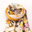 Modern hand-woven mixed fibre scarf. Luxurious hand-woven scarf in modal, wool, silk & cashmere-incredibly soft to the touch you can hardly feel it! Design is hand-printed using traditional methods of silk screen and lithographic wood block and shows pottery pieces with flowers. An absolutely gorgeous gift for someone special. Main photo of scarf rolled up as if around a neck