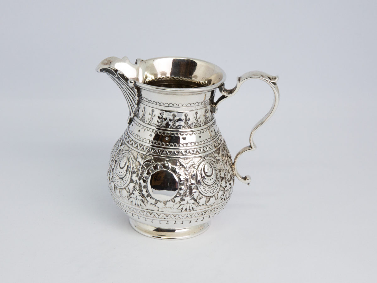 c1875 Small sterling silver jug. Very sweet and finely decorated small jug by Barnard & Sons Ltd. Full hallmark to the base for London assay. Stunning piece with empty cartouche to either side for personalisation. Measures 40mm in diameter at the base, 85mm from tip of spout to edge of handle and 45mm across the top. Main photo of jug shown from an eye level angle with spout to the left