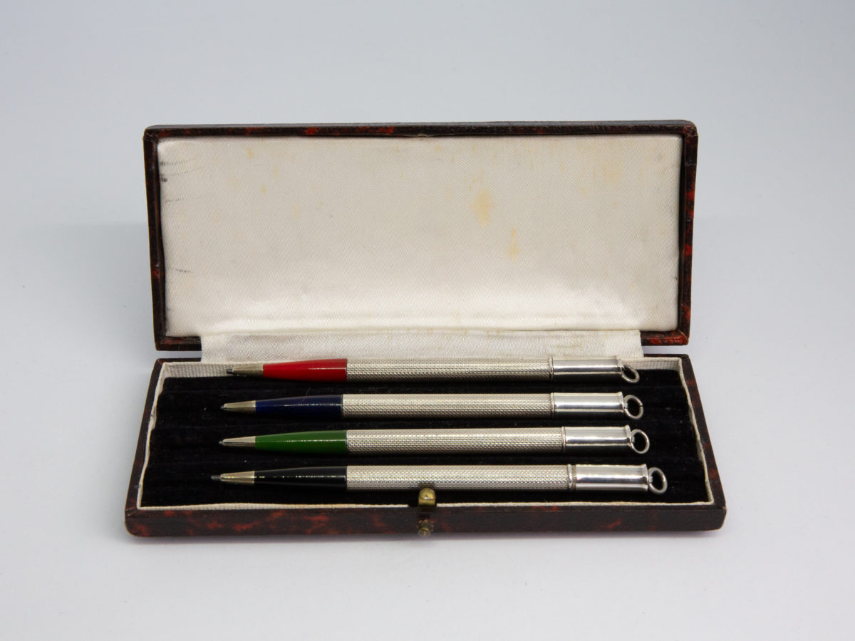 Cased set of 4 silver bridge pencils. Lovely vintage set of 4 pencils with different coloured ends in black, green, blue & red. Each pencil marked sterling silver and measures 95mm long and weighs 6.5gms. Main photo of all 4 pencils laid in the open case