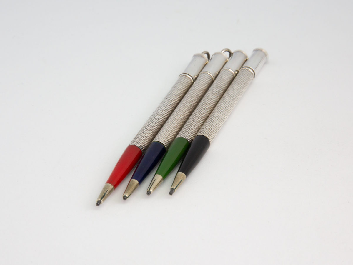 Cased set of 4 silver bridge pencils. Lovely vintage set of 4 pencils with different coloured ends in black, green, blue & red. Each pencil marked sterling silver and measures 95mm long and weighs 6.5gms. Photo of all 4 pencils laid side by side with front coloured ends in the foreground