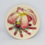 Moorcroft Frangipani Plumeria dish. Small round dish in cream with frangipani plumeria blossom. Stamped Moorcroft to the back and dated c1999. Measures 120mm in diameter and 75mm at base. Main photo of dish showing the frangipani design strain on