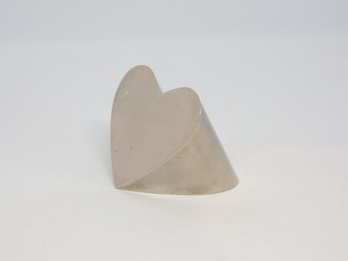 Vintage 1970s Heart paperweight. Highly collectable heavy silver plate heart shaped paperweight made by Dansk, Japan. Some minor scratches and stains consistent with age. Measures 63mm at widest, 60mm at tallest. Main photo of paperweight shown from a slight side angle with heart front to the left of photo.