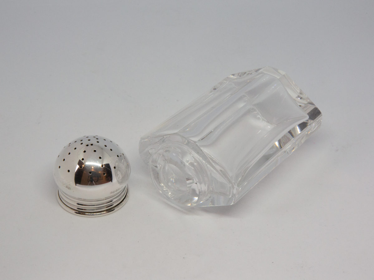 Continental silver topped sugar sifter. Lovely Deco sugar sifter with heavy crystal glass bottom and 835 silver top. Full hallmark to the side of the silver top believed to be of German origin. In excellent condition with no chips or cracks. Photo of sifter laid flat and shown with silver top removed and placed to the left side of glass body top.