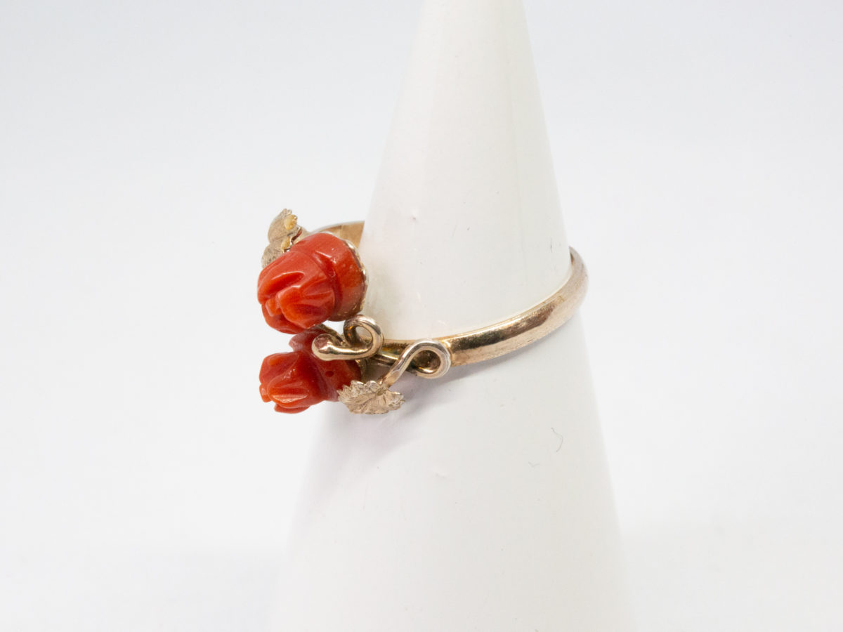 Continental carved coral roses ring. Pretty Continental gilt silver ring set with two carved red coral roses mounted on gilt silver leaves. Open band design. Size P. Hallmark to outside band (worn 800) Will be sent boxed. Photo of ring on a cone display stand and shown with ring front facing left.