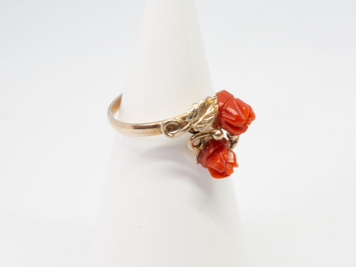 Continental carved coral roses ring. Pretty Continental gilt silver ring set with two carved red coral roses mounted on gilt silver leaves. Open band design. Size P. Hallmark to outside band (worn 800) Will be sent boxed. Photo of ring on a cone display stand and showing with ring front facing right.