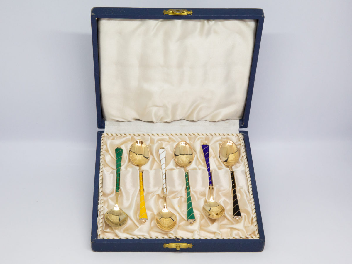 Set of 6 mid century coffee spoons. Lovely set of 6 gilt sterling silver and enamel coffee spoons by Egon Lauridsen of Denmark in original case. Each spoon with a different colour enamel to the handle. Hallmarked Ela Denmark Sterling 925S to the back. Each spoon measure approximately 93mm long and weighs 7.6gms. Photo of spoons displayed inside the case.