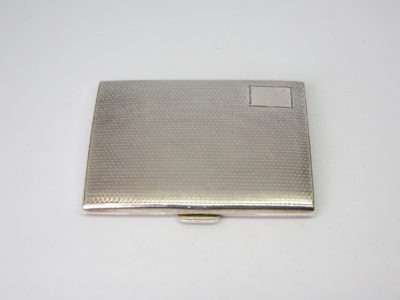 Small sterling silver cigarette case. c1929 Birmingham assayed sterling silver Art Deco cigarette case/business card holder. Lovely engine turned design to both sides with an empty cartouche to the lid for personalisation. Worn gilt interior with elastic intact. Hallmark to both inside covers and a lion passant on the opening lip. Main photo of closed case looking down from above showing the empty cartouche in the top right corner.