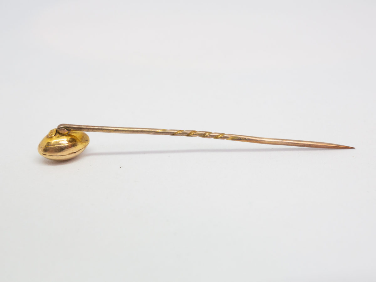 Victorian 15 karat gold stick pin. Beautifully crafted rugby ball stick pin. Hallmarked 15ct to back of ball. Definitely one for the lover of rugby ! Measures approximately 60mm long and weighs 2.5gms. Rugby ball measures approximately 10mm long. Photo of stick pin on a flat surface with ruby ball face down