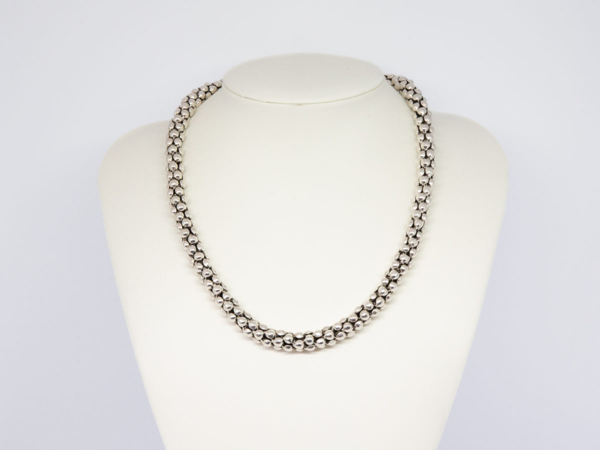 Modern sterling silver necklace. Unusual silver necklace with a bubbles or water droplets like chain. Nice length so closer to neck like a choker. Hallmarked 925 to the link. Main photo of necklace displayed on a stand.