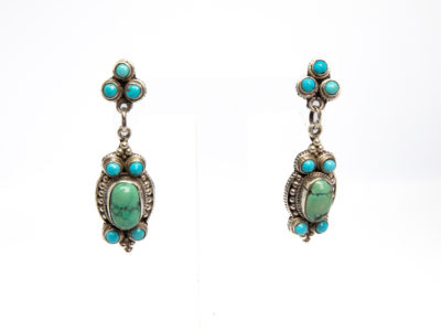 Navajo sterling silver and turquoise earrings. Lovely pair of Native American sterling silver earrings set with 2 shades of turquoise stones.Hallmarked 925 to back of both earrings and to butterfly clasps. Drop length approximately 60mm and width at widest point 18mm. Main photos of earrings displayed on a clear stand.