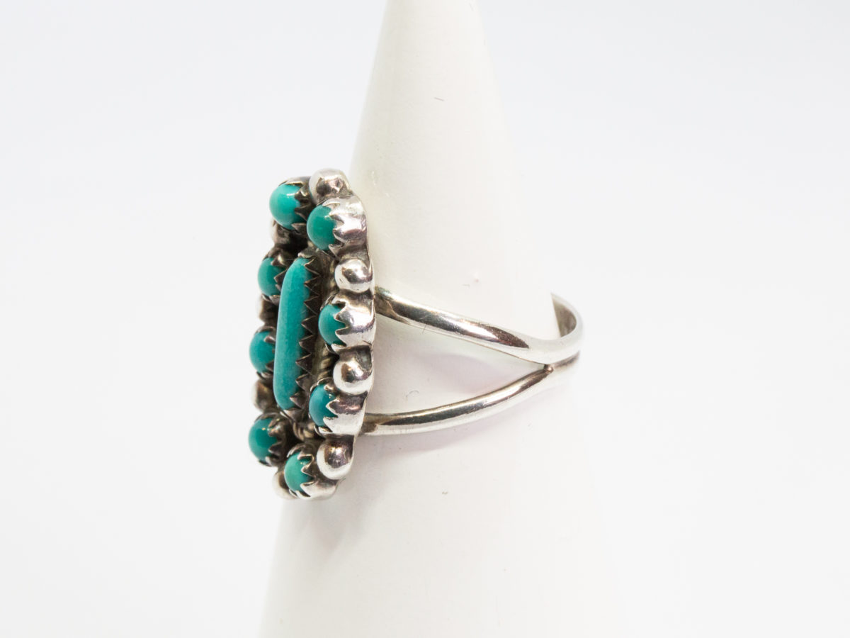 Vintage Navajo silver and turquoise ring. Sterling silver ring set with Bisbee blue turquoise. Stamped sterling with initials BB to the back for Benson Boyd. Wonderful example of fine Native American craftmanship. Ring size M / 6. Ring front measures 22mm by 15mm. Ring weight 4.3gms. Photo of ring on a cone display stand with ring front facing left of photo.