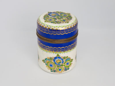 1950s Steinböck Studio lidded pot. Beautiful enamel pot in a creamy off white, hand-painted with a floral design in vibrant greens and blues & all accentuated with 24 karat gold leaf. In excellent condition throughout with no damage to the enamel just wear of the gold leaf around the pot opening as would be expected. Steinböck mark to the base. Measures approximately 64mm in diameter. Main photo of pot showing the larger decoration to the side of pot which is same as that on lid.