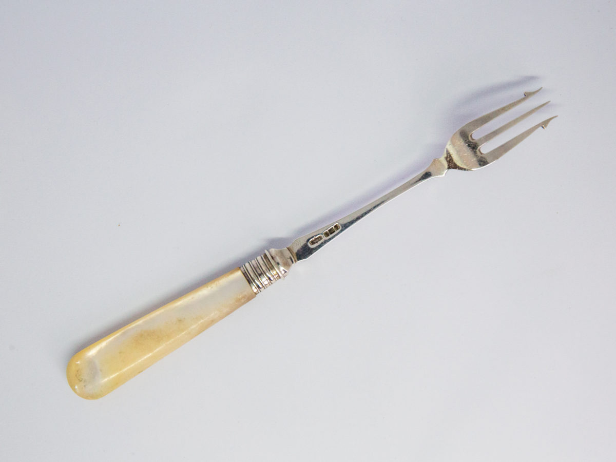 Antique silver and mother-of-pearl pickle fork. Fine sterling silver pickle fork in excellent condition with a mother-of-pearl handle. Full hallmark to the back of fork for Sheffield assay c1899 and made by James Dixons & Sons. Photo of fork shown diagonally across the page with prong end in top right of photo and fork face down showing the hallmark.