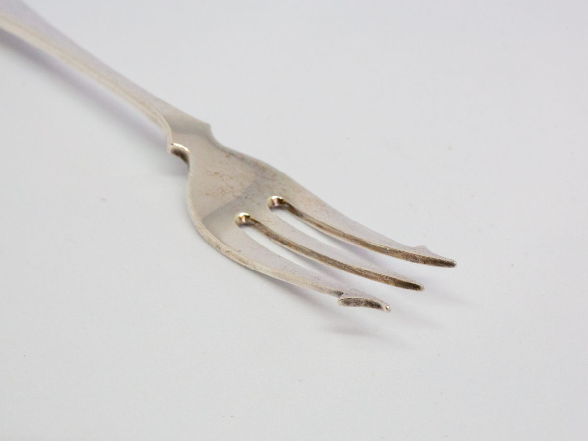 Antique silver and mother-of-pearl pickle fork. Fine sterling silver pickle fork in excellent condition with a mother-of-pearl handle. Full hallmark to the back of fork for Sheffield assay c1899 and made by James Dixons & Sons. Close up photo of the fork tines.