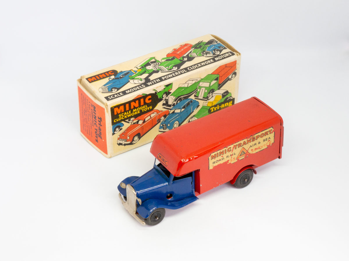 Vintage Minic clockwork delivery van. Wonderful Minic clockwork toy van including original key and box. Van measures approximately 150mm long by 46mm wide and 62mm tall. Photo of delivery van lined up diagonally with its box with van front facing bottom left of photo.