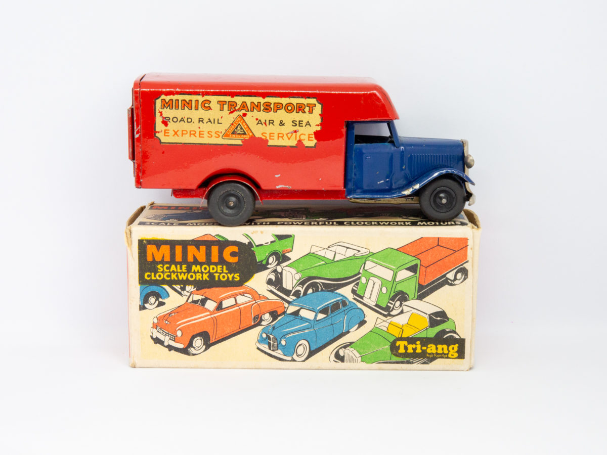 Vintage Minic clockwork delivery van. Wonderful Minic clockwork toy van including original key and box. Van measures approximately 150mm long by 46mm wide and 62mm tall. Photo of van on top of its box sideways on with van front facing right.