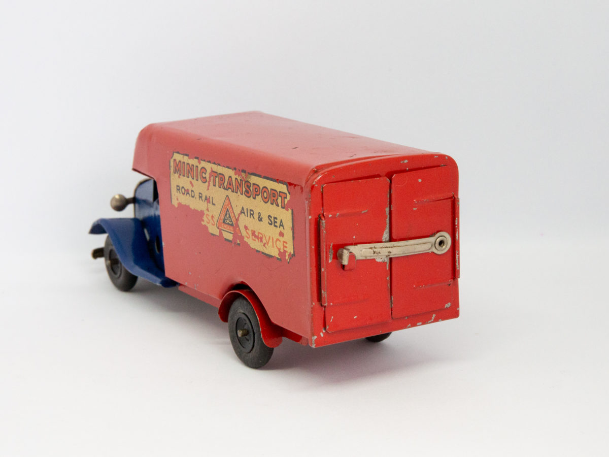 Vintage Minic clockwork delivery van. Wonderful Minic clockwork toy van including original key and box. Van measures approximately 150mm long by 46mm wide and 62mm tall. Photo of van set at a diagonal angle with back of van in the foreground and to the bottom right of photo.