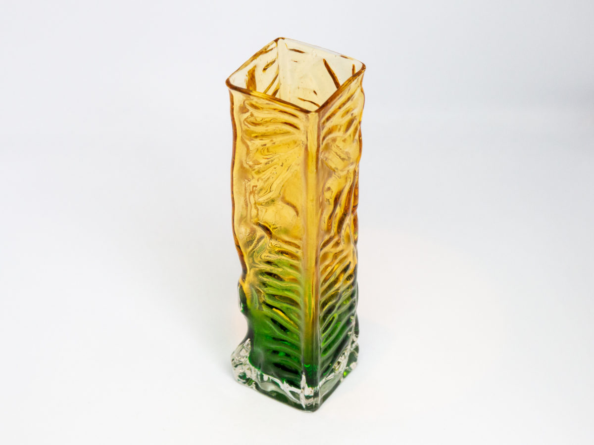 Whitefriars small rectangular vase. Small and sweet Whitefriars rectangular glass vase with a vibrant green base and yellow top. Measures 47mm square at base. Photo of vase from a slight raised angle and showing corner edge section