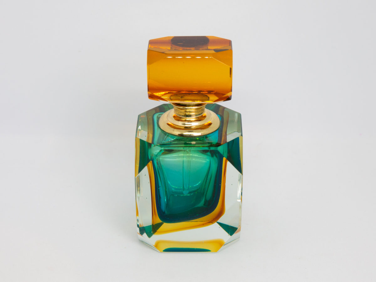 Mid century modern Murano glass perfume bottle. Small stunning Murano Sommerso perfume bottle in burnt amber, aqua and clear glass. Screw top stopper with brass neck and clear glass applicator. A really beautiful piece of modern glass art attributed to Flavio Poli. Photo of bottle with top flush with bottom angle.