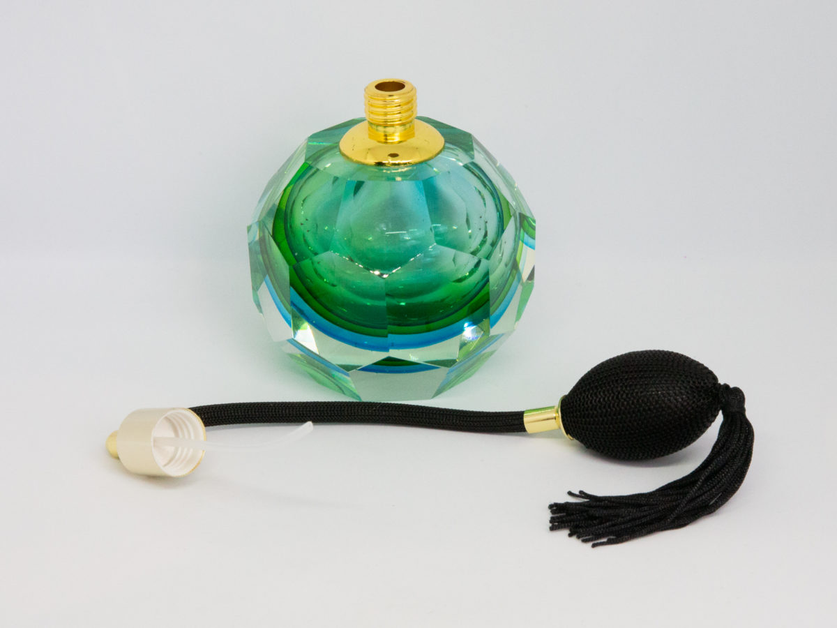 Mid century modern Murano glass perfume atomiser. A gorgeous hexagonal Murano Sommerso perfume atomiser bottle in aqua green and blue finished with a brass top and long black spray atomiser bulb. Attributed to Flavio Poli. Measures 55mm in diameter at base and 85mm in diameter at most bulbous central area. Photo of bottle with atomiser unscrewed and placed in front of the bottle.