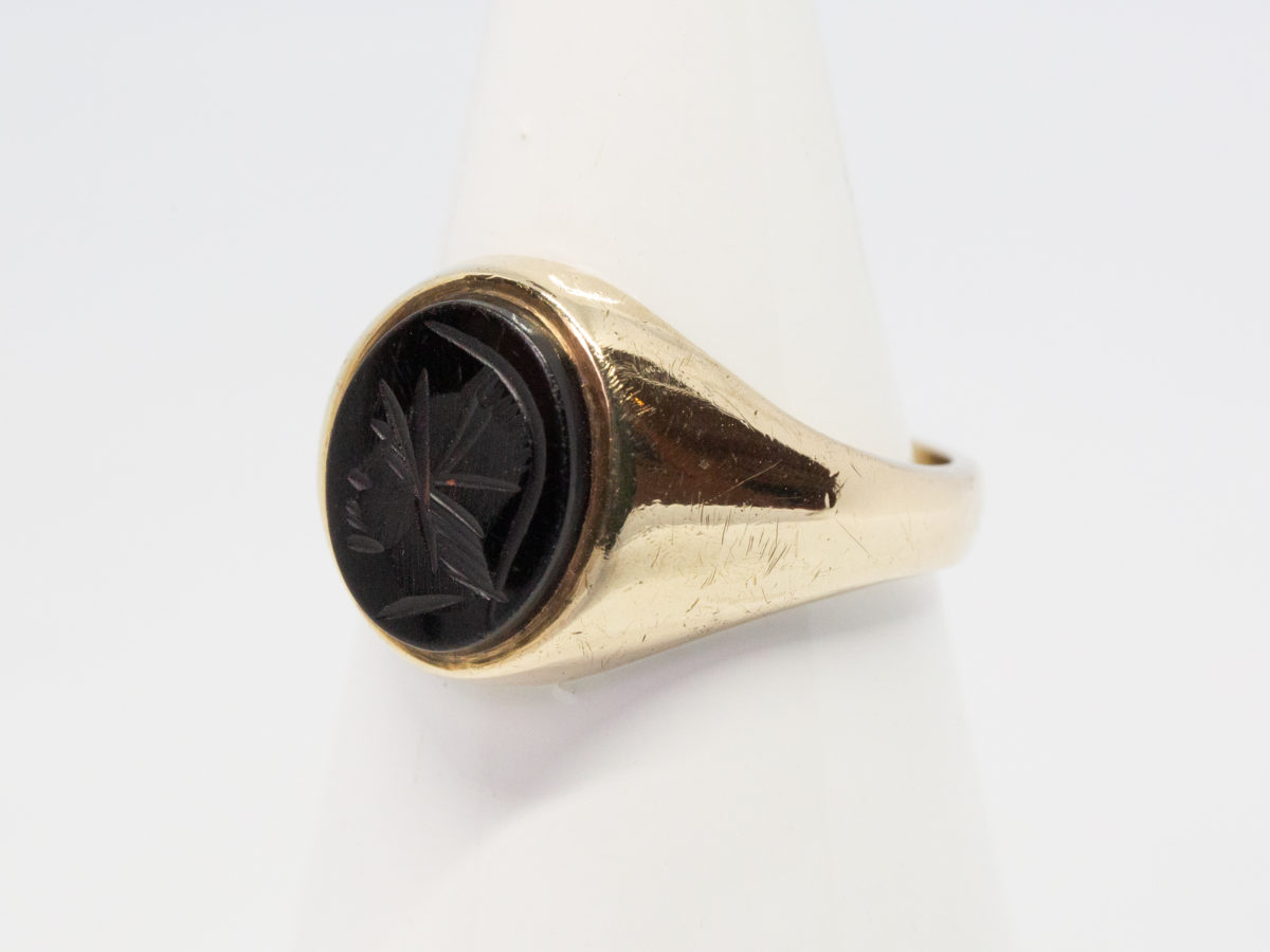 Vintage 9 karat gold and hematite ring. c1978 Birmingham assayed 9 karat gold ring set with a hematite intaglio showing profile of a Roman soldier. Ring size T.5 / 9.75 Photo of ring on a cone shaped display stand with ring front facing towards left of photo