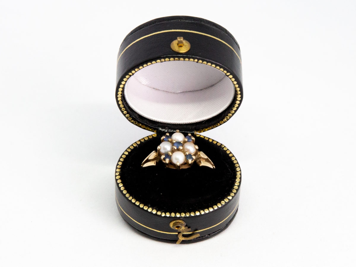 Vintage 9 karat gold, sapphire and pearl ring. Pretty 9 karat gold ring set with 5 small round cut blue sapphires and seed pearls. Hallmarked for Continental import with Birmingham assay. Ring size Q / 8. Ring weight 3.2gms. Photo of ring displayed in a ring box.