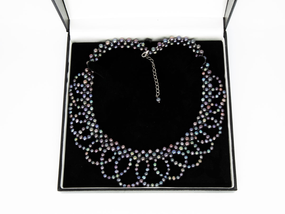 Modern black pearl necklace in a collar form. Intricately designed necklace with multiple iridescent black pearls and finished with a sterling silver clasp and slightly adjustable chain. Box included. Adjustable from approximately 400mm to 455mm. Necklace weight 57.6 grams. Photo of necklace displayed in its box.