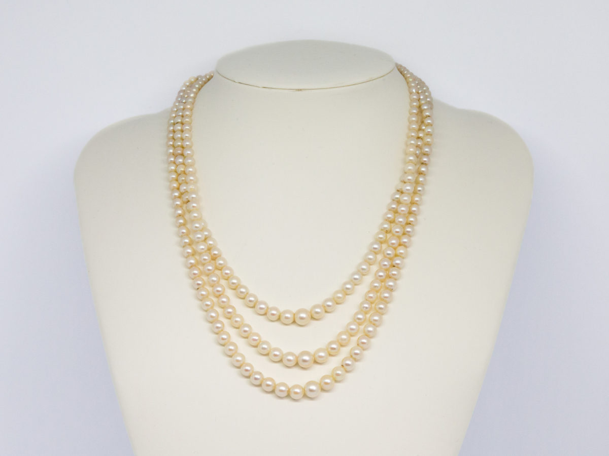 Art Deco graduated pearl necklace. Stunning necklace with 3 strands of graduated pearls and a paste stone encrusted clasp. Unidentifiable hallmark to back of clasp. Made in France. Shell shaped box included but not original. Shortest strand measures approximately 420mm and longest 450mm. Necklace weight 47gms. Main photo of necklace displayed on a stand.