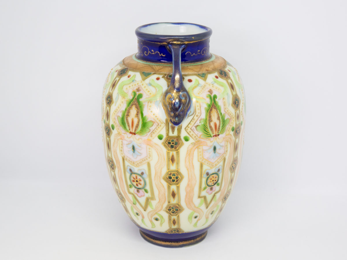 Hand-painted Noritake vase from the Art Deco era. Here we have a beautifully hand-painted bulbous vase with 2 fine handles and decorated in an Oriental Art Deco pattern. In superb condition. Date estimated to between 1918-1921. Measures approximately 58mm in diameter at base and at mouth and 125mm at widest across the base of each handle. Photo showing vase from the side with handle to the centre top.