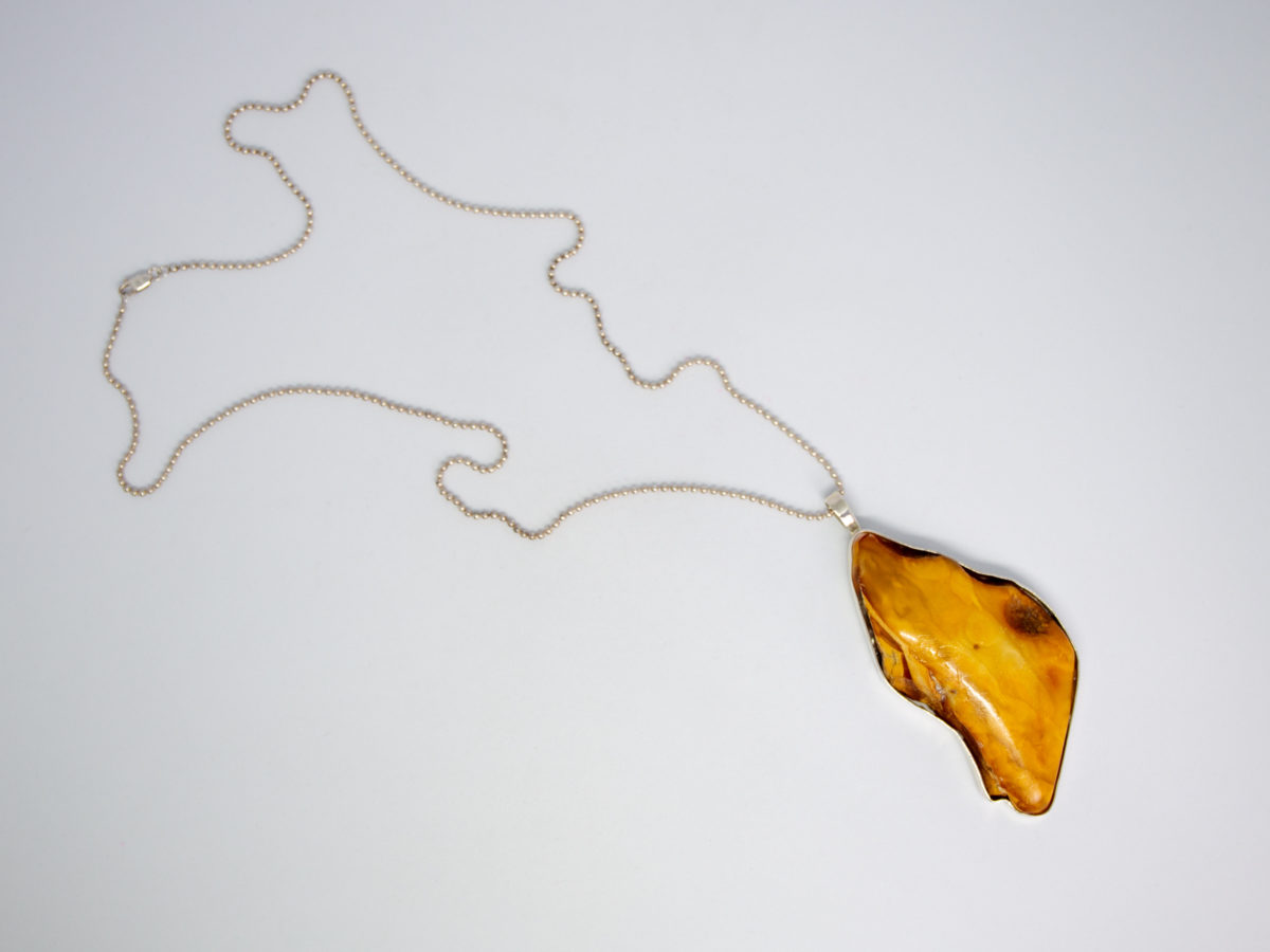 Rare large egg yolk amber pendant and chain. Stunning huge egg yolk amber set in a sterling silver frame on a sterling silver ball chain. Hallmarked to the pendant bail for London assay c1997 and 925 on the chain clasp. Pendant drop length 95mm and 45mm at widest. Photo of pendant & whole chain laid out on a flat surface.