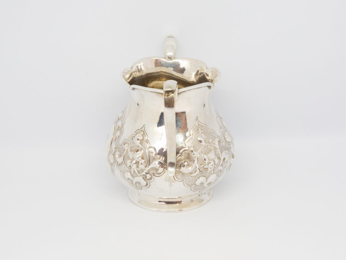 Antique 2 handled sterling silver pot. Small 2 handled sterling silver pot with intricate relief pattern around the lower bulbous area. One cartouche has a profile of a medieval knight engraved to it while other cartouche is empty - for a damsel perhaps? Shapely handles and rim add to the elegance of this piece. Full hallmark to the base for London assay c1875. Made by Francis Higgins. Base measures 55mm in diameter, width across handles measures approximately 105mm and opening at top 60mm in diameter. Photo of pot from the side with handle to the middle.