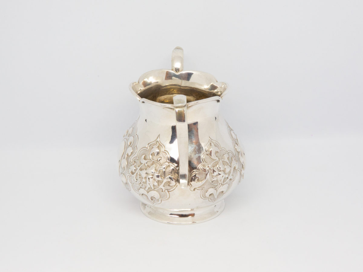 Antique 2 handled sterling silver pot. Small 2 handled sterling silver pot with intricate relief pattern around the lower bulbous area. One cartouche has a profile of a medieval knight engraved to it while other cartouche is empty - for a damsel perhaps? Shapely handles and rim add to the elegance of this piece. Full hallmark to the base for London assay c1875. Made by Francis Higgins. Base measures 55mm in diameter, width across handles measures approximately 105mm and opening at top 60mm in diameter. Photo of other handle side of pot.