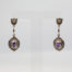Modern sterling silver and amethyst earrings. Pretty pair of earrings in an Art Deco style with oval cut amethyst and marcasite. Hallmarked 925 for sterling silver to the back of each earring and butterfly. Earring drop length approximately 45mm. Lower part of earring housing the amethyst measures 25mm by15mm. Main photo of earrings on a display stand and forward facing.