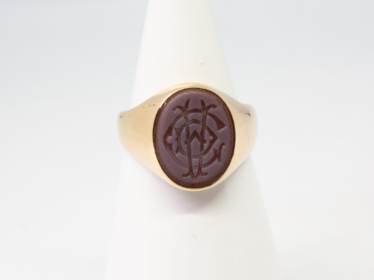 Vintage 9 karat gold seal ring. A nice solid ring in 9 karat gold with superimposed letters C, D & A in intaglio (hollow relief) to the agate stone. Hallmarked 9ct to inside band. Ring front measures approximately 14mm by 12mm. Box included. Ring size R / 8.5 Ring weight 8.9gms. Photo of ring displayed on a cone shaped stand and seen front facing.